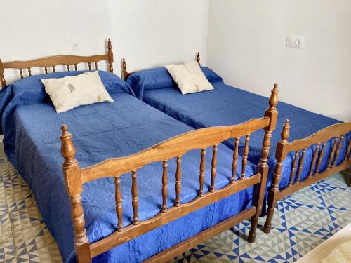 two beds in a room with blue sheets at 2 bedrooms apartement with balcony and wifi at Albunol 7 km away from the beach in Albuñol