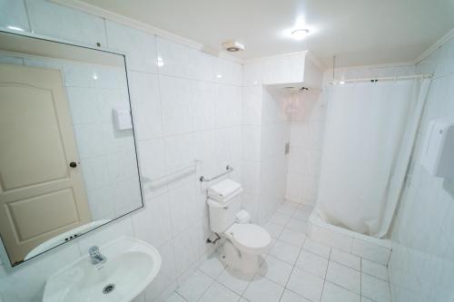 biała łazienka z toaletą i umywalką w obiekcie Hotel Vitali w mieście Concepción
