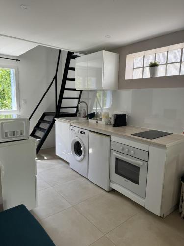 une cuisine avec un lave-linge et un escalier dans l'établissement Maison de 40m2,Clim, Wifi, jardin et parking, à Marseille