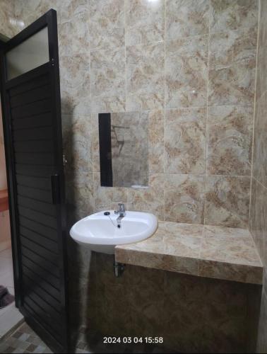 a bathroom with a sink and a mirror at Karjo Homestay Syariah in Ngadipuro