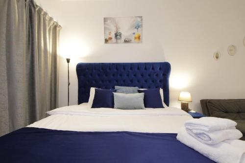 a bedroom with a blue bed with towels on it at Silk Valley - Furnished Studio With Balcony in Abu Dhabi