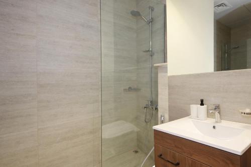 a bathroom with a shower and a sink at Silk Valley - Furnished Studio With Balcony in Abu Dhabi