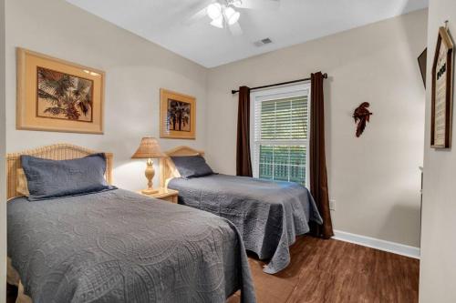 a bedroom with two beds and a window at Main Level End Unit Condo In North Myrtle Beach in North Myrtle Beach