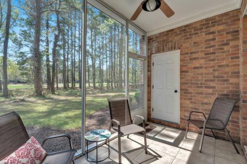 a screened porch with three chairs and a white door at Main Level End Unit Condo In North Myrtle Beach in North Myrtle Beach