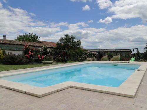 a swimming pool with blue water in a yard at Le gite du gueurlet in Boresse-et-Martron