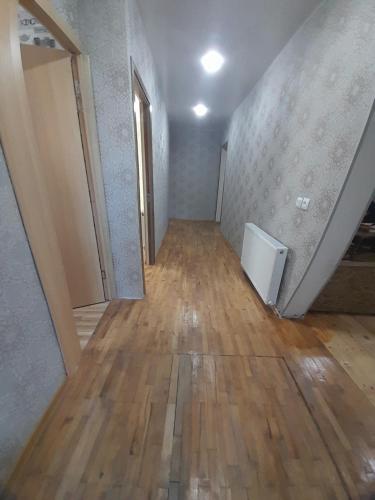 an empty room with a hard wood floor and a hallway at HOTEL LukaRabati in Akhaltsikhe