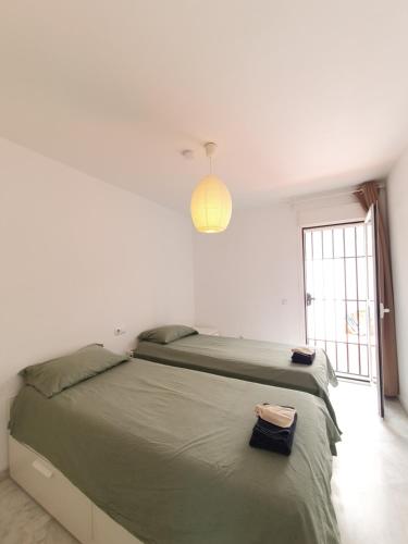 a bedroom with a large bed with a light above it at Quiet en montemar in Torremolinos