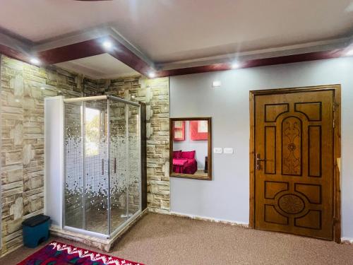 a room with a glass door and a stone wall at Bedouin Panorama House in Wadi Musa
