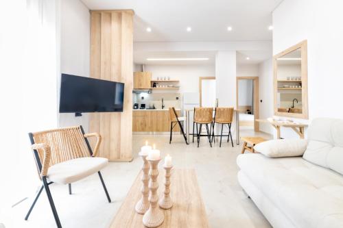 a living room with a white couch and a table at SoL Suites Pefkochori in Pefkohori