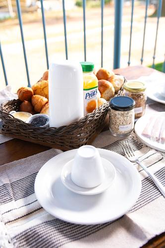 un tavolo con un cesto di pane e un piatto di Chalé Alto Serra a Tiradentes