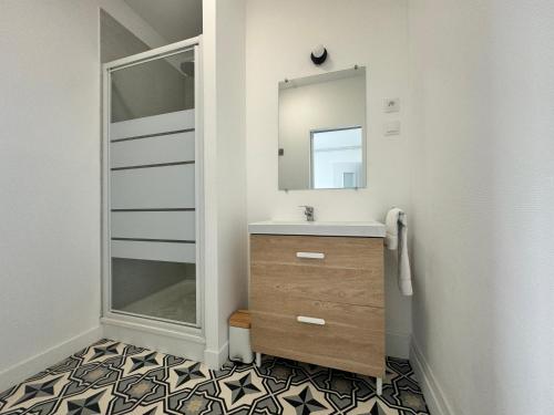 une salle de bain avec un lavabo et un miroir dans l'établissement La Criée, un balcon sur le port, à Boulogne-sur-Mer