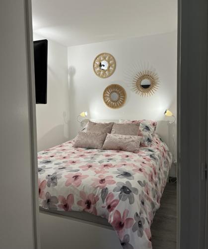 une chambre avec un lit et une horloge au mur dans l'établissement L'Appart St Aygulf, 5mn à pied mer, piscine, tennis, à Fréjus