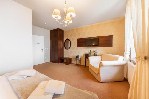 a hotel room with a bed and a chair at Hotel Plumlov in Mostkovice