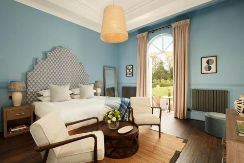 um quarto com uma cama, uma mesa e cadeiras em Down Hall Hotel em Bishops Stortford