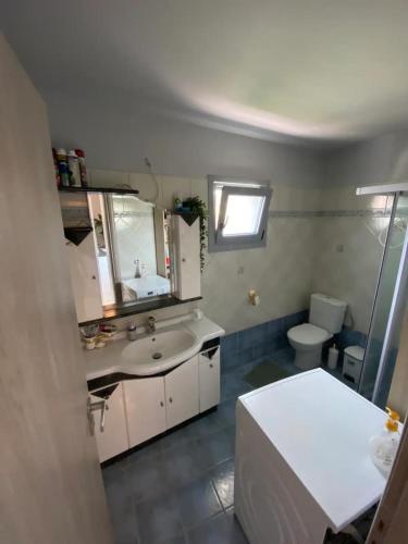 a bathroom with a sink and a toilet at Evie’s Apartment in Perdika