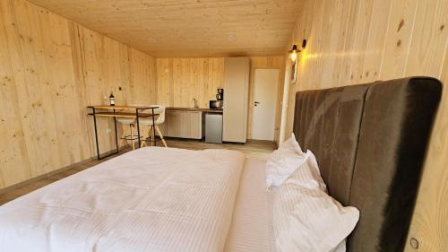 een groot bed in een kamer met een keuken bij Sycamore Retreat Fundata in Fundata