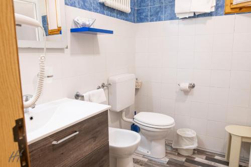 a white bathroom with a toilet and a sink at Hotel Holiday- Alla Finestrella in Bologna
