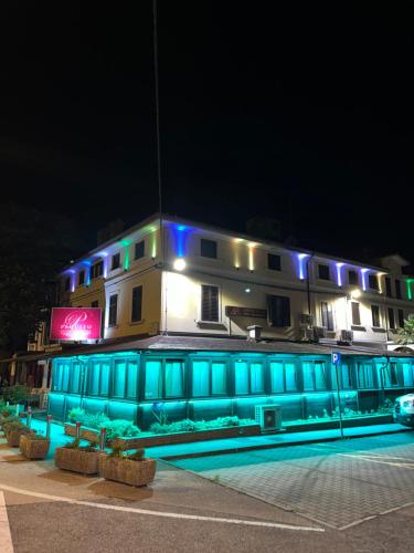 un edificio con luces azules por la noche en Hotel Paquito en Nova Gorica