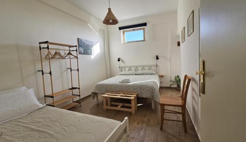 a bedroom with two beds and a table and chairs at Home Alle Cascate in Corleone