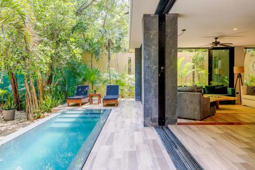 an infinity pool in a house with a living room at Luxurious Oasis Jacuzzi with Art Gallery and Pool in Tulum