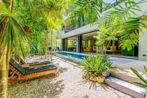 a house with a swimming pool and palm trees at Luxurious Oasis Jacuzzi with Art Gallery and Pool in Tulum