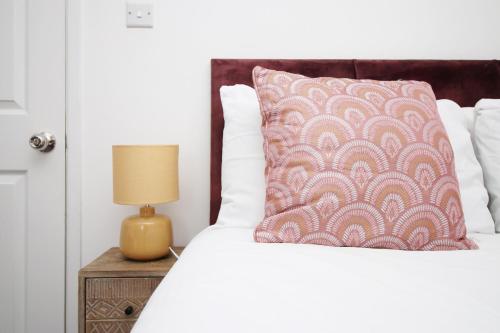 a bed with a pillow and a lamp on a night stand at 2 Bedroom House on Holmes Hill Road- Free Parking, Wi-Fi & Patio in Bristol