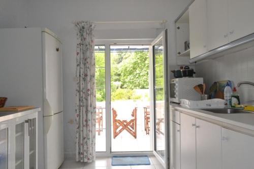 a kitchen with a door leading to a patio at Summer Family House with sea view and garden in Kriopigi