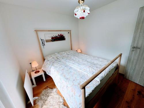 a bedroom with a bed and a chandelier at Cozy House Didi 
