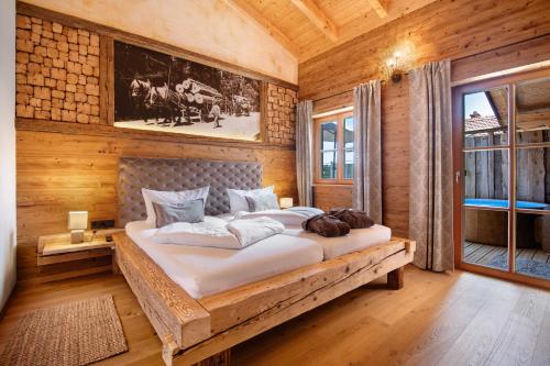 Cama grande en habitación con paredes de madera en Bergchalet 2 en Freyung