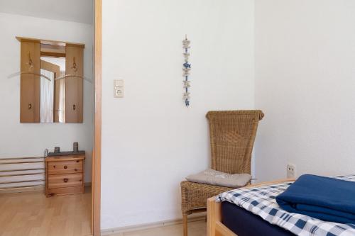 a bedroom with a bed and a chair and a mirror at An der Silberfuchsbörse in Engbüttel