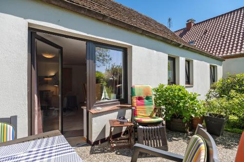 a patio with a sliding glass door and a chair at An der Silberfuchsbörse in Engbüttel