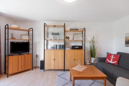 a living room with a couch and a tv at An der Silberfuchsbörse in Engbüttel