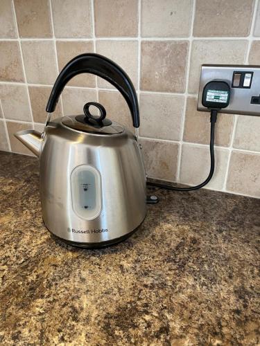 a tea kettle sitting on a counter next to a phone at Mallards Barn on a rural farm in Dingestow