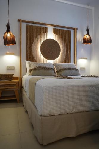 ein Schlafzimmer mit einem großen Bett und zwei Leuchten in der Unterkunft L A Boutique Suites with Private Hot Tub in Kalathas