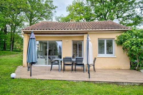 a patio with a table and chairs and umbrellas at Gite Deodatus avec piscine in Cladech
