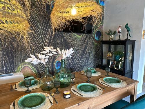 a wooden table with green plates and vases on it at Tibo - Casal do Conde in Caldas de Reis