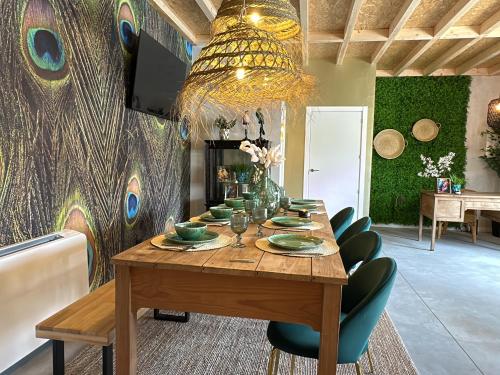a dining room with a wooden table with green chairs at Tibo - Casal do Conde in Caldas de Reis