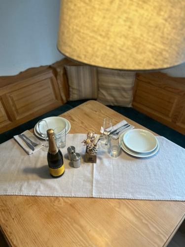 a table with a bottle of wine and plates and a bottle at Ferienwohnung Bärenblick Achensee in Eben am Achensee