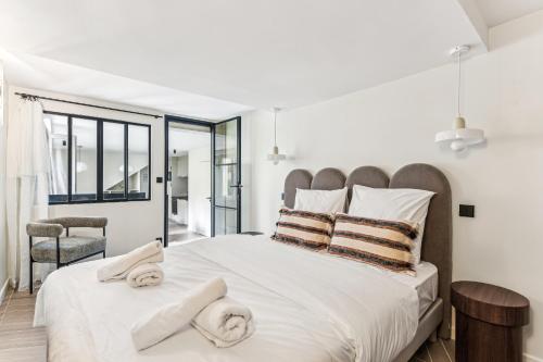 une chambre avec un grand lit avec des serviettes dessus dans l'établissement Rare pearl-Apt d'architecte-Auteuil, à Paris