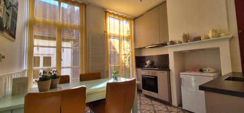 a kitchen with a table and chairs and a kitchen with windows at Appartement in het oude centrum van Zutphen in Zutphen