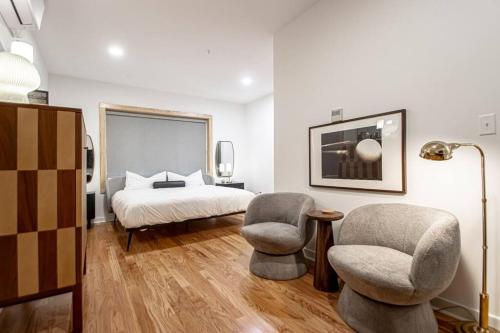 a bedroom with two chairs and a bed at Historic Downtown Studio, Walk to Bathhouses, Room # 100 in Hot Springs