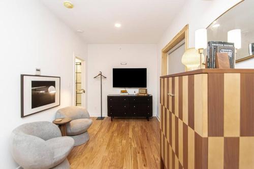a living room with two chairs and a television at Historic Downtown Studio, Walk to Bathhouses, Room # 100 in Hot Springs