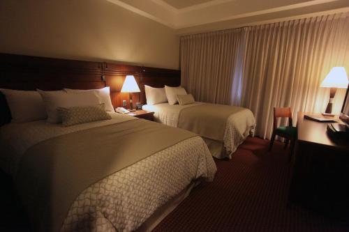 a hotel room with two beds and a window at EXECUTIVE SUITES VALENCIA in Valencia