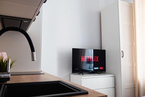 ワルシャワにあるMini kawalerka w samym Centrum Warszawyの冷蔵庫の上にテレビが置かれたキッチン