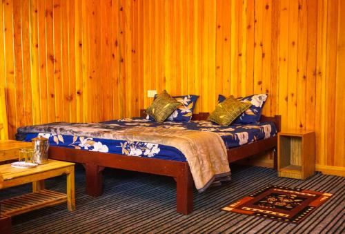 um quarto com uma cama numa parede de madeira em Pine Valley Homestay em Nainital