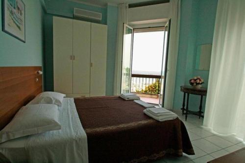 リミニにあるHotel Acapulcoのベッドルーム(大型ベッド1台、大きな窓付)