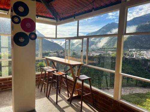 a table and chairs in a room with a large window at Habitación privada con terraza panorámica, cocina, parqueadero in Baños