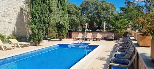 a swimming pool with lounge chairs next to a building at Hotel Sara De Ur in La Cabrera