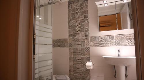 La salle de bains est pourvue d'un lavabo et d'un miroir. dans l'établissement Hotel Viky, à Sarti