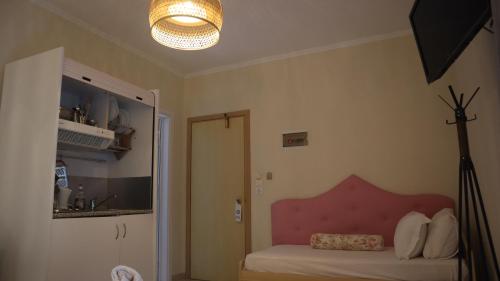 um quarto com uma cama com uma cabeceira rosa e uma luz em Hotel Viky em Sarti
